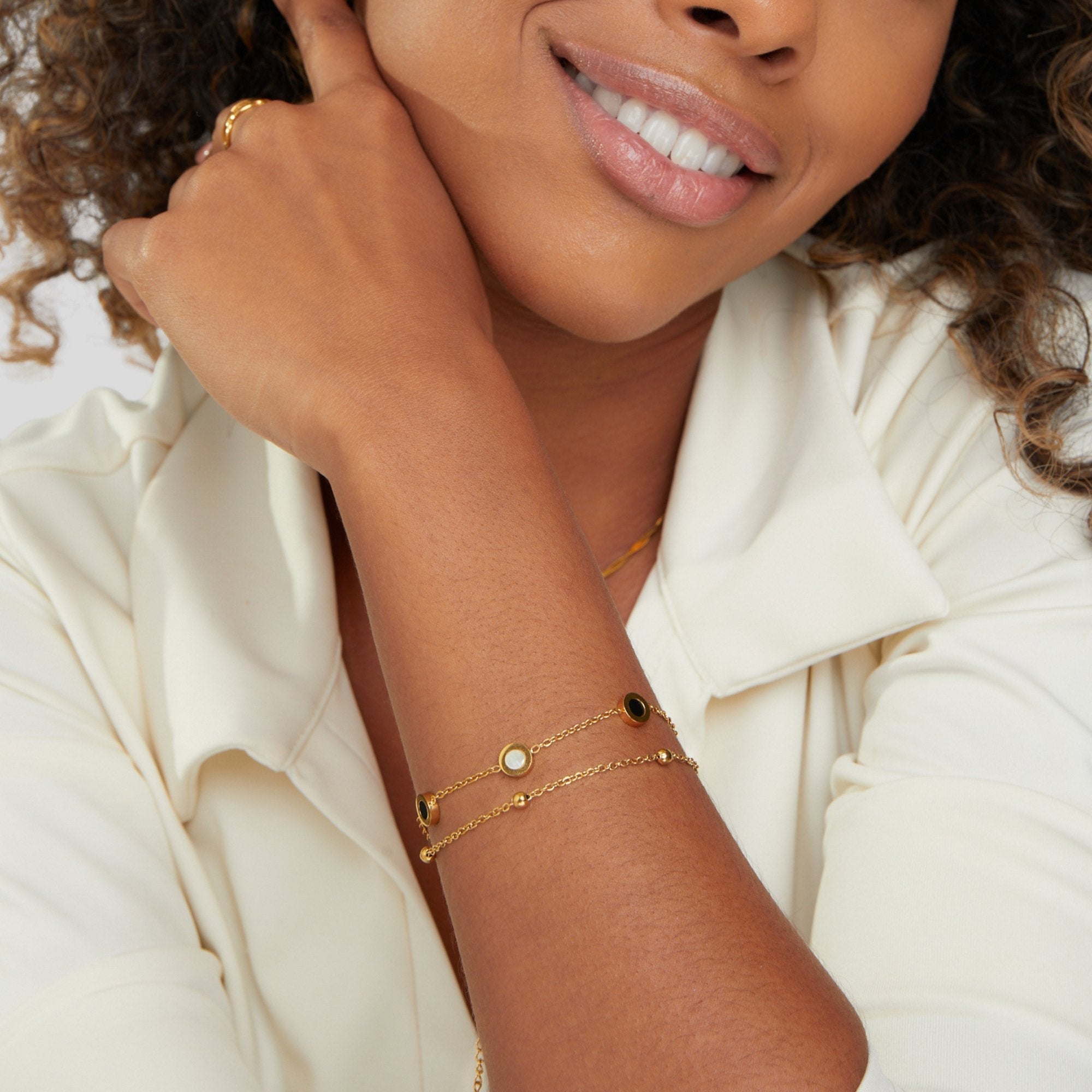 Carla – Blød guldarmbånd med kontrastfyldte runde elementer.